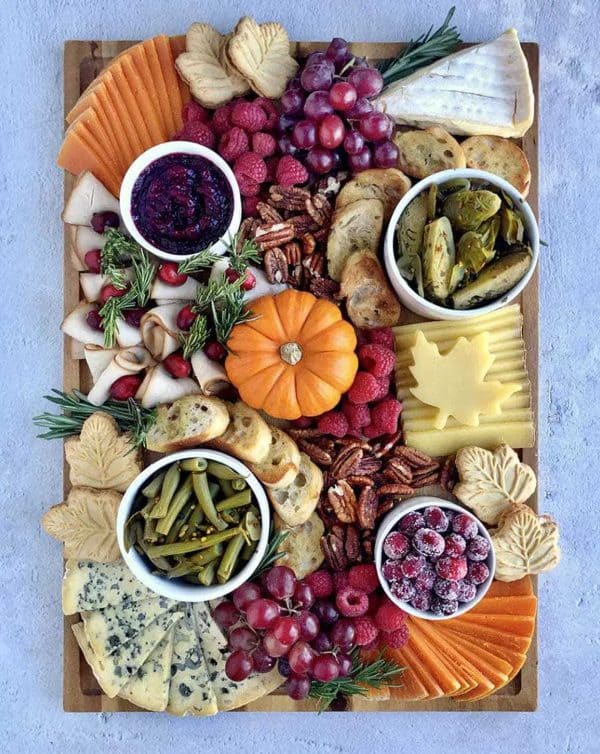 Image shows a thanksgiving cheese board with other fall ingredients.
