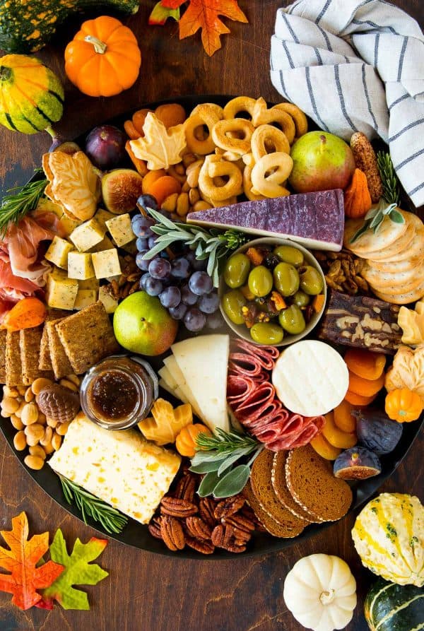 Image shows a Thanksgiving charcuterie board with Fall decorations.