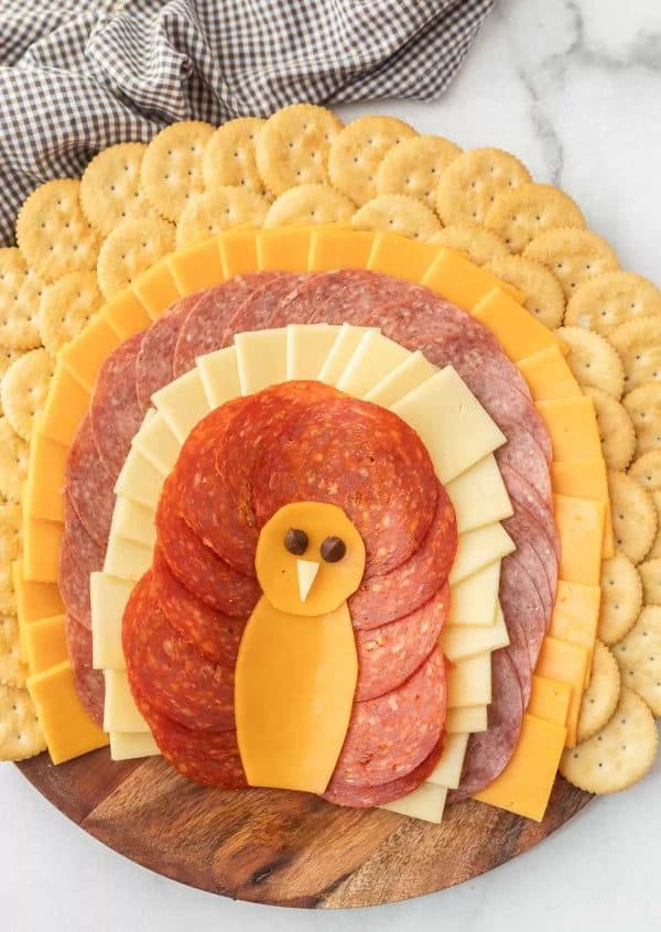 Image shows a simple thanksgiving charcuterie board shaped like a turkey.