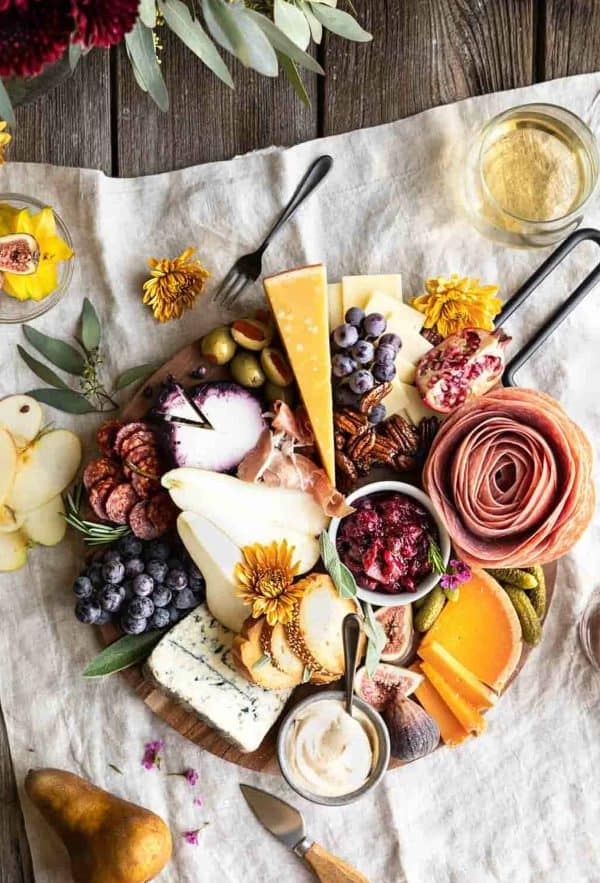 Image shows a fall themed thanksgiving charcuterie board with decorations.