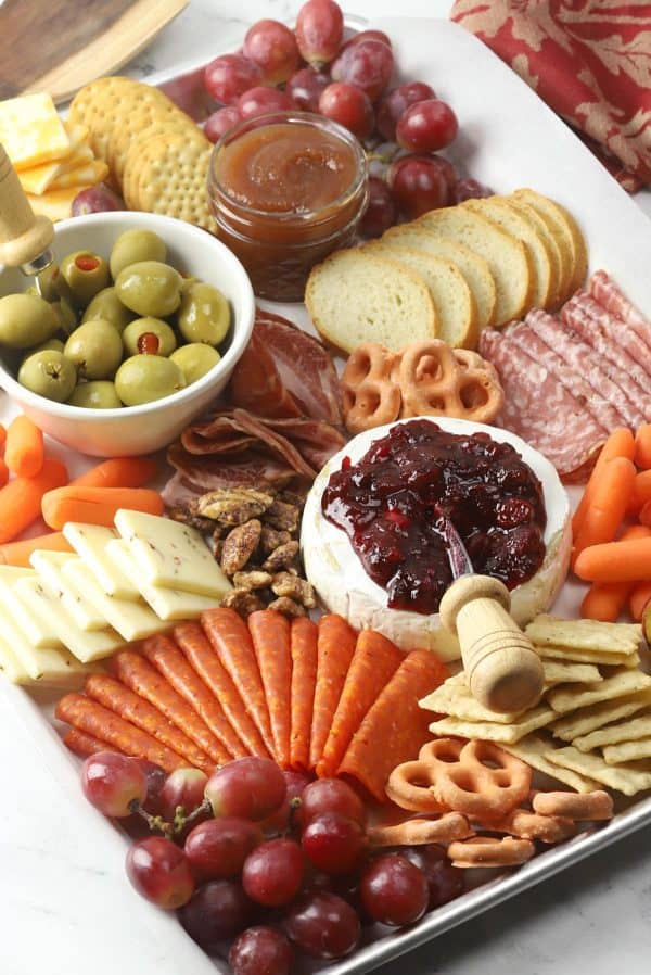 Image shows a thanksgiving charcuterie board with cranberry sauce, pretzels, crackers, and more.