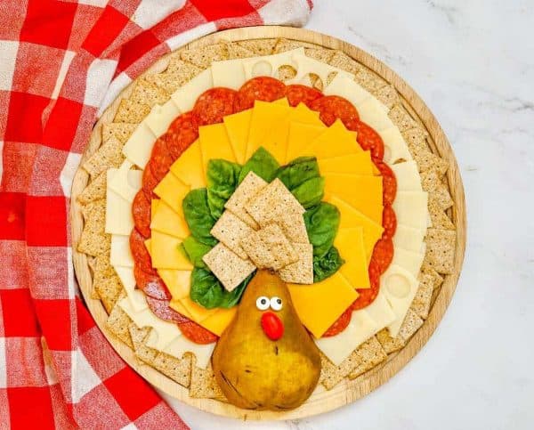 Image shows a turkey-shaped charcuterie board with a thanksgiving theme.