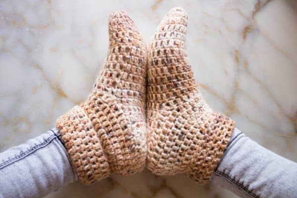 crochet socks on feet on marble background skip to my lou