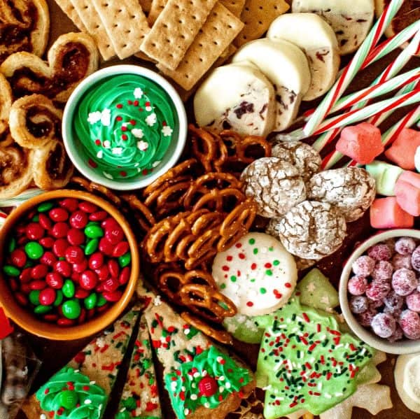 Image shows a christmas dessert charcuterie board with pretzels, cookies, and other sweets. via chenee today.