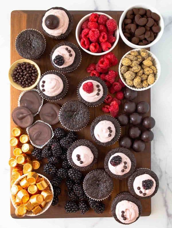 Image shows a dessert charcuterie board with fresh fruits, cupcakes, and more desserts. via desserts for two