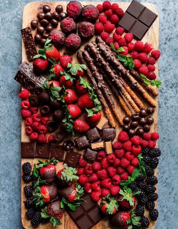 Image shows a dessert board with chocolate, strawberries, berries, pretzels and more sweet treats. via the rainbow plant life.