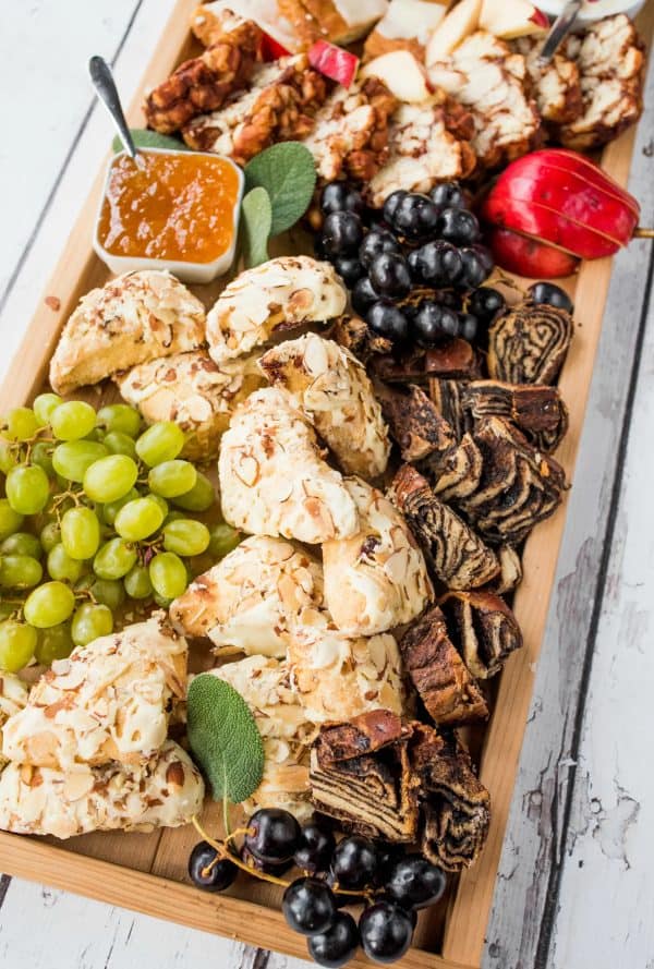 Image shows a christmas board with desserts, jams, fruits, and more. via reluctant entertainer