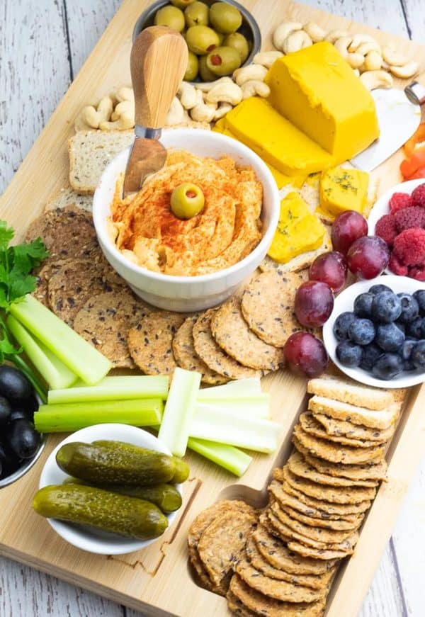 Image shows a hummus charcuterie board with fruits and cheese.