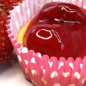 closeup of mini strawberry cheesecake tart next to strawberries