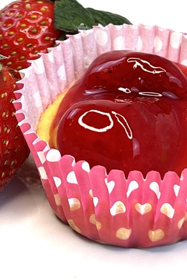 closeup of mini strawberry cheesecake tart next to strawberries