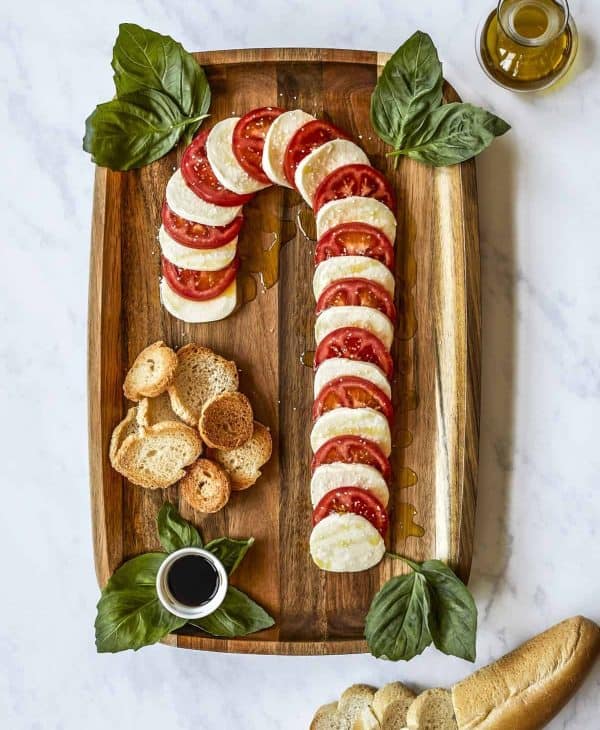 candy cane charcuterie board ideas- a board with simple mozzarella and tomatoes with a balsamic glaze. 