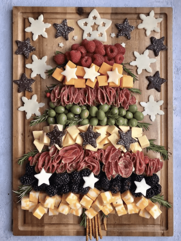 christmas tree charcuterie board ideas- a oard full of fresh fruit, cheese, and meat
