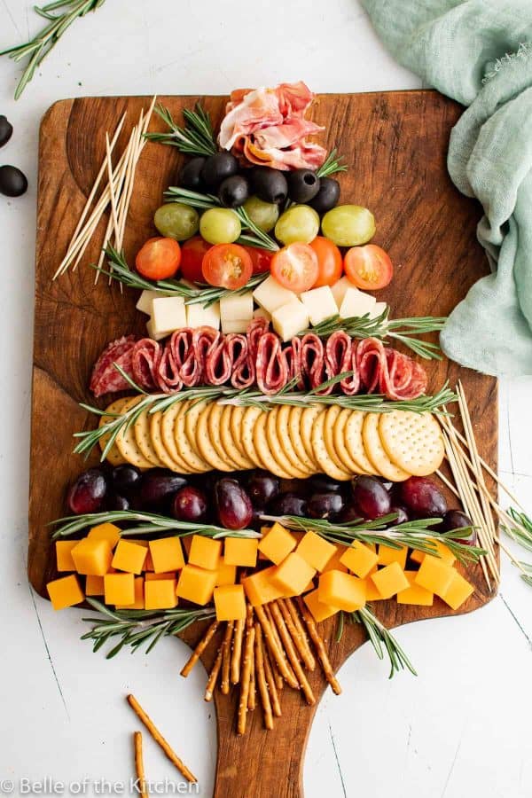 christmas tree charcuterie board ideas- a large board with grapes, tomatoes, crackers, cheese, and more. 