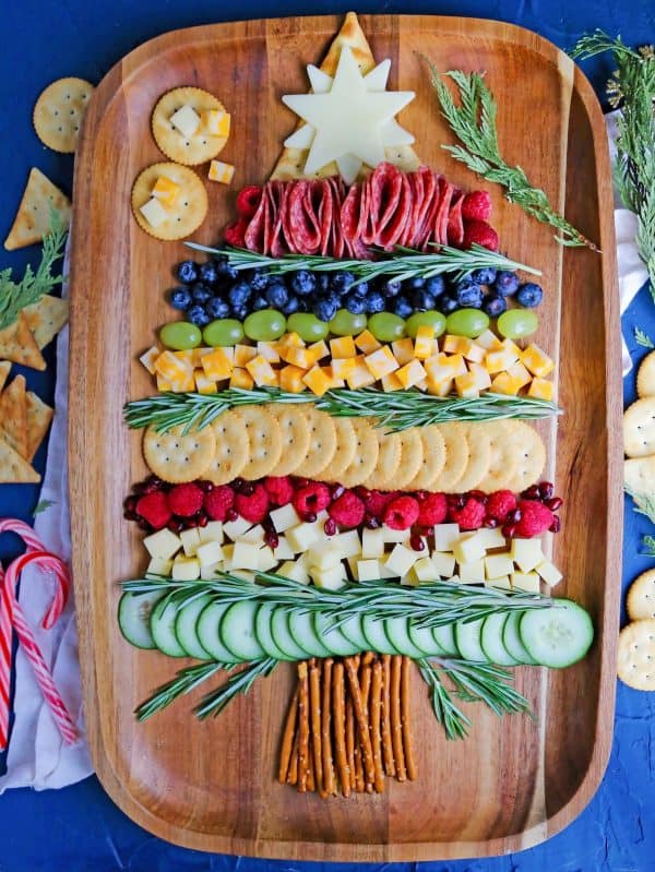 christmas tree charcuterie board ideas- a large board with blueberries, meat, cucumbers, and more. 