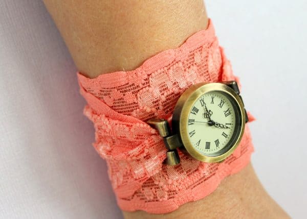 Pink lace cuff watch around a wrist.