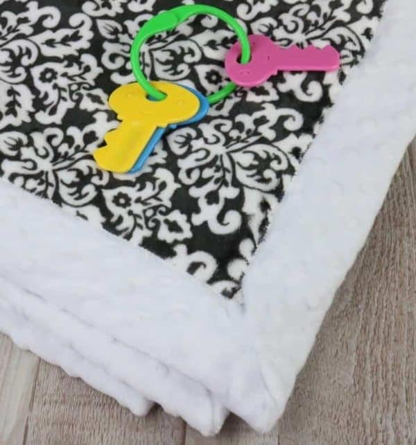 Image shows a minky baby blanket with baby toy keys.