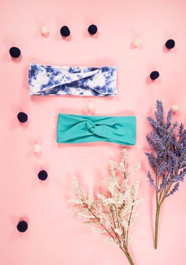Twisted headbands on a pink background with lavender plants next to them.