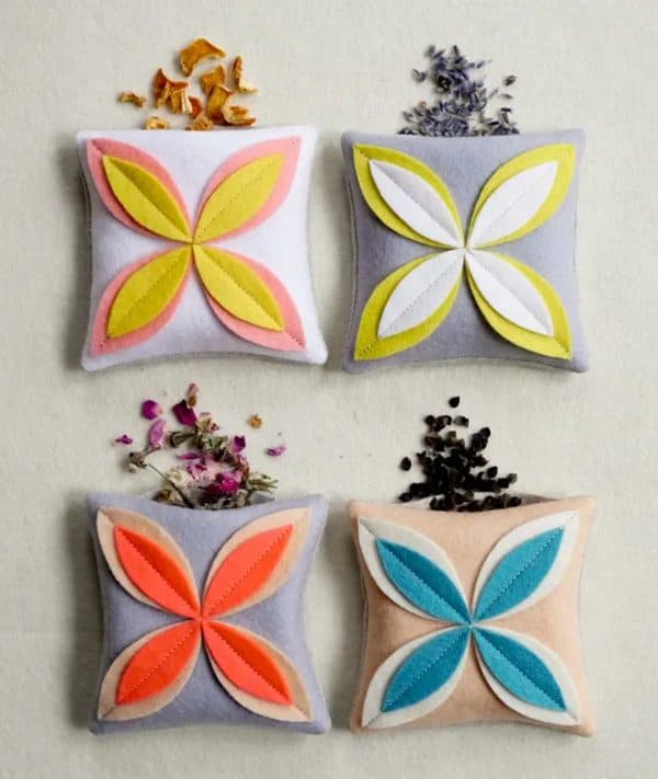 4 different flower sachets with dried flowers outside of them.