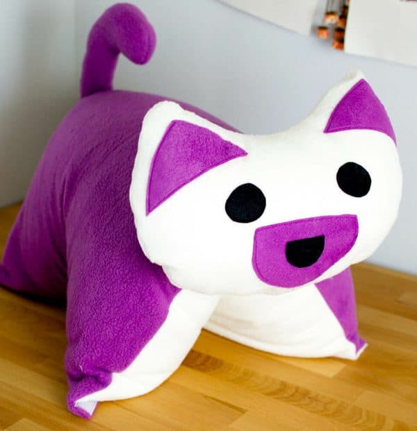 Purple handmade puppy pillow on the floor.