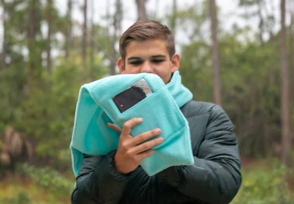 Image shows a man wearing a fleece scarf with a cell phone pocket.