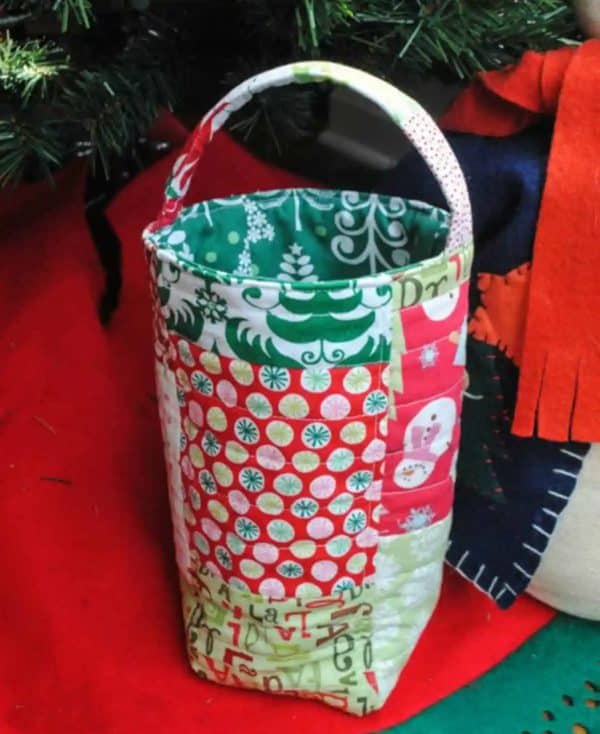Image shows a quilted wine bottle tote bag with christmas decorations.