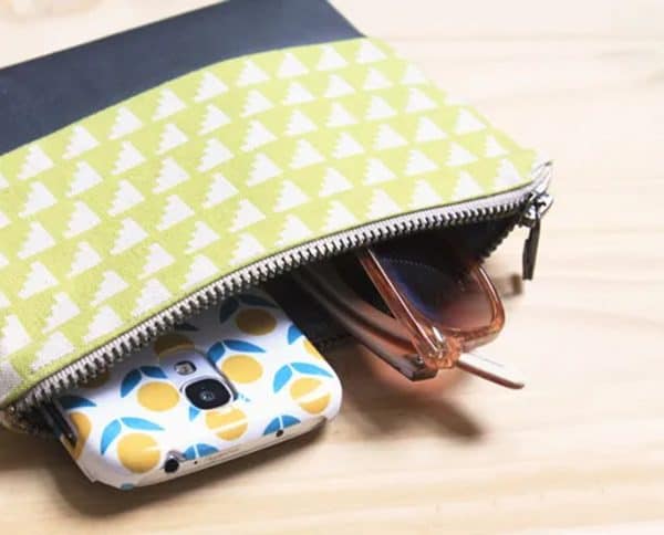 Image shows a zippered pouch wiht a phone and sunglasses inside.