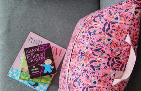 Image shows a reading pillow with books next to it.