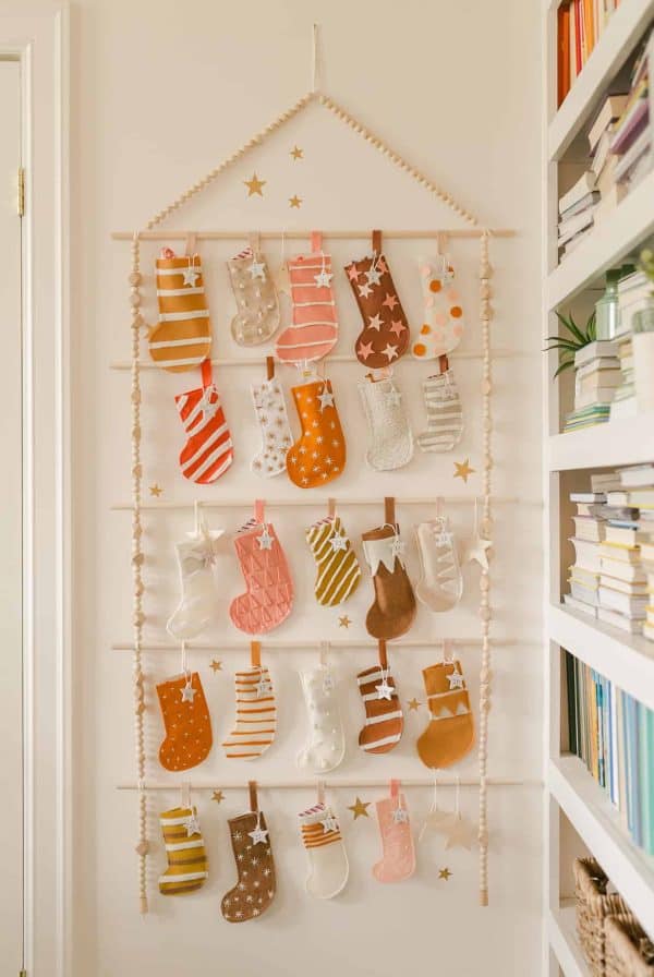 Image shows a stocking felt advent calendar hanging from. wall.