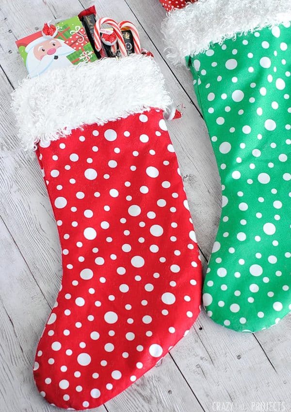 Image shows two Christmas stockings with candies inside.