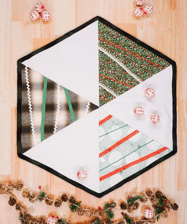 Image shows a christmas tree table topper with ornaments on it.