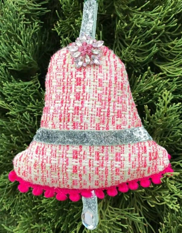 Imag shows an old-style vintage ornament hanging from a tree.
