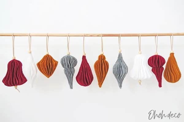 Image shows a christmas ornament set hanging from a piece of wood.
