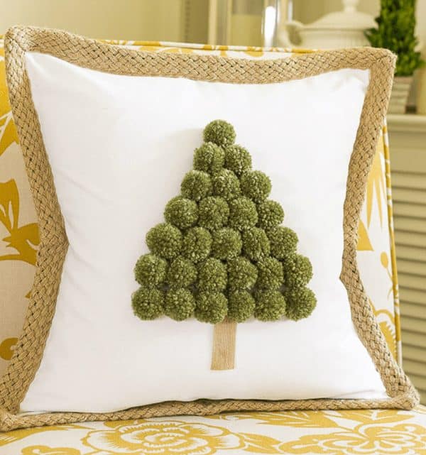 Image shows a Christmas tree pom pom pillow. 