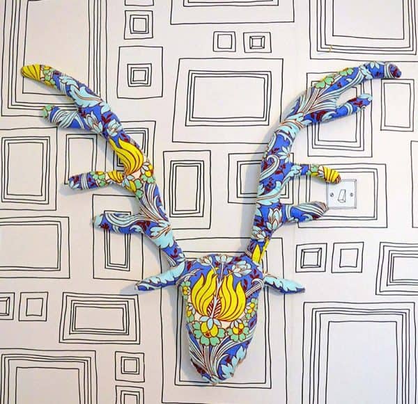 Image shows a colorful stag head decorated with patterns.