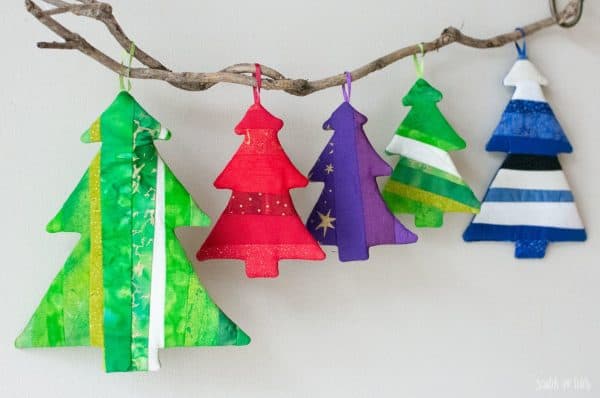 Image shows five DIY christmas ornaments made with fabric scraps hanging from a branch.