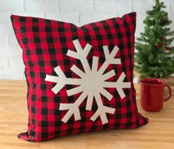Image shows a pillow with a snowflake decoration sewn into it.