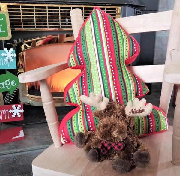 Image shows a tree-shaped pillow with a Christmas theme.
