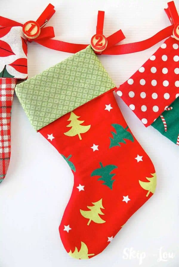 Image shows a sew stocking hanging from a wall with pins.