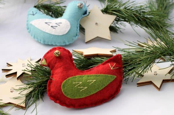 image shows two felt-sewed birds on a christmas tree.
