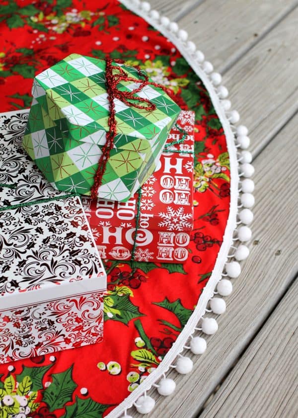 Image shows a christmas skirt with presents on top of it.