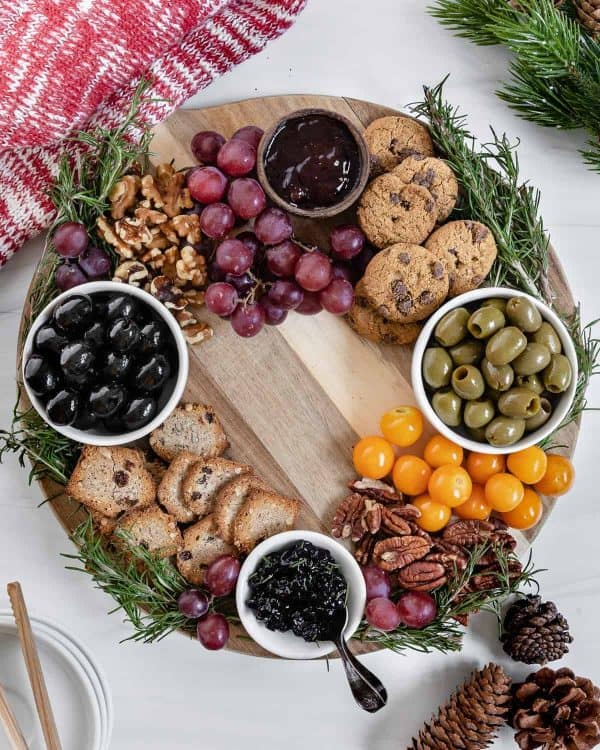 wreath charcuterie board ideas- a wreath with olives, grapes, and desserts like cookies.