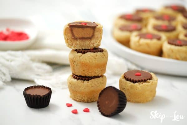 Three Reece's Peanut Butter Cup cookies stacked up with the top cookie cut in half to show the peanut butter inside, by Skip to my Lou.