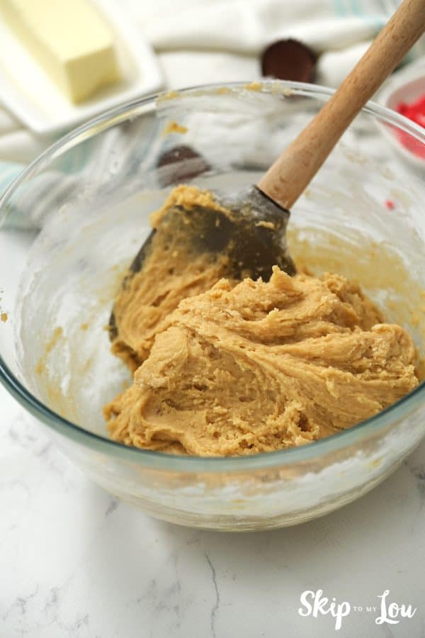 Round glass mixing bowl with spatula and peanut butter cookie dough inside, by Skip to my Lou.