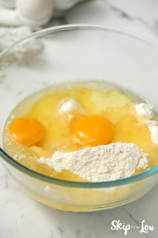 Glass mixing bowl with cake mix and 2 eggs inside, by Skip to my Lou.