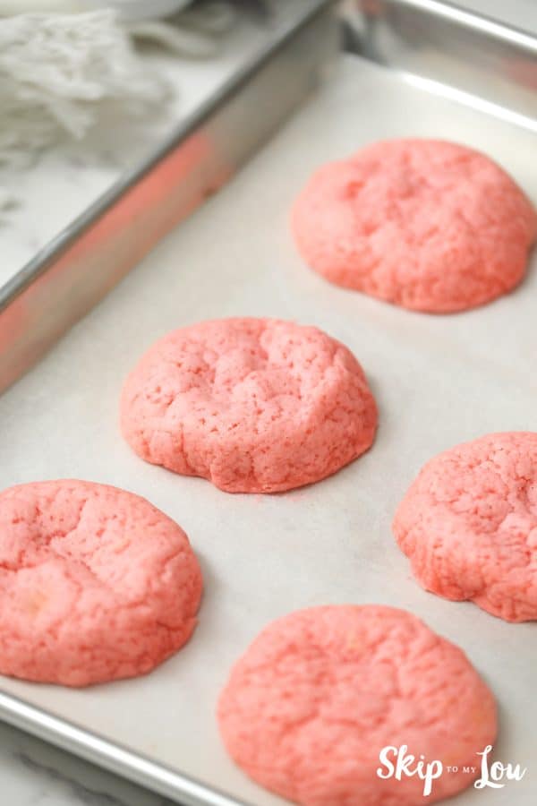 6 pink strawberry cookies baked on a cookie sheet, by Skip to my Lou.