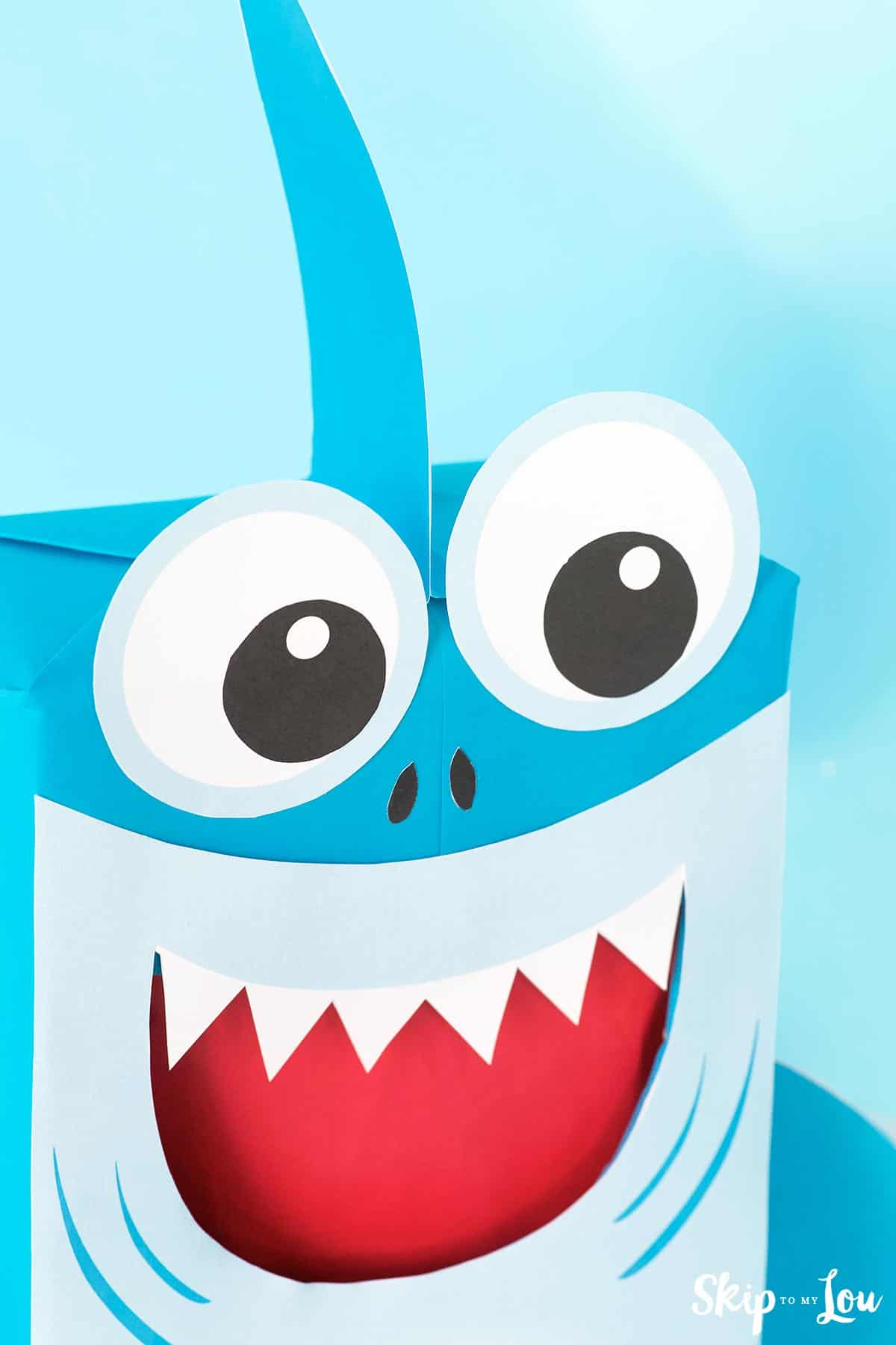 Blue shark Valentine box with huge eyes, sharp teeth, red tongue and friendly grin by Skip to my Lou.