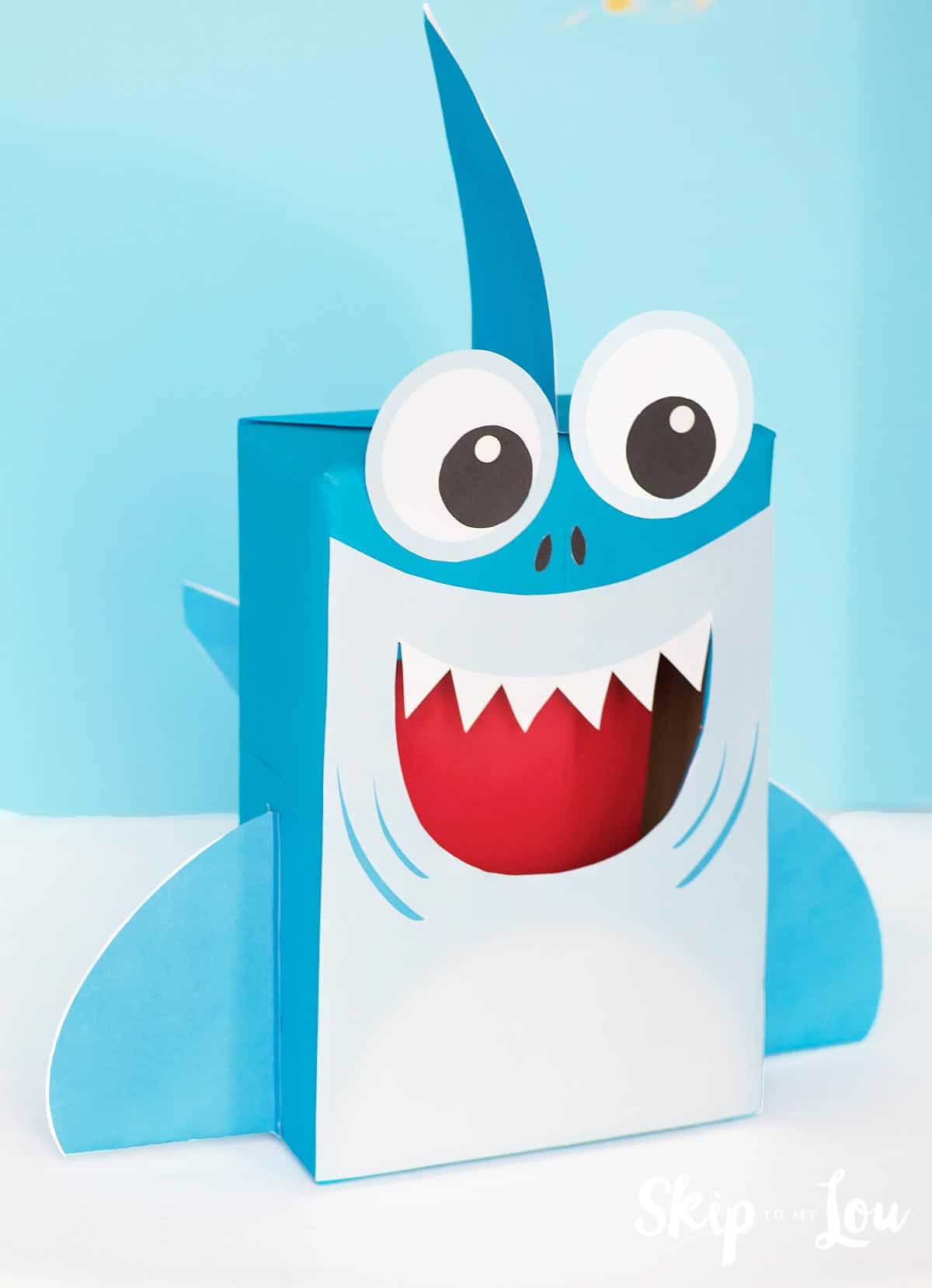 Blue smiling shark Valentine box with fins, sharp teeth and large eyes by Skip to My Lou.