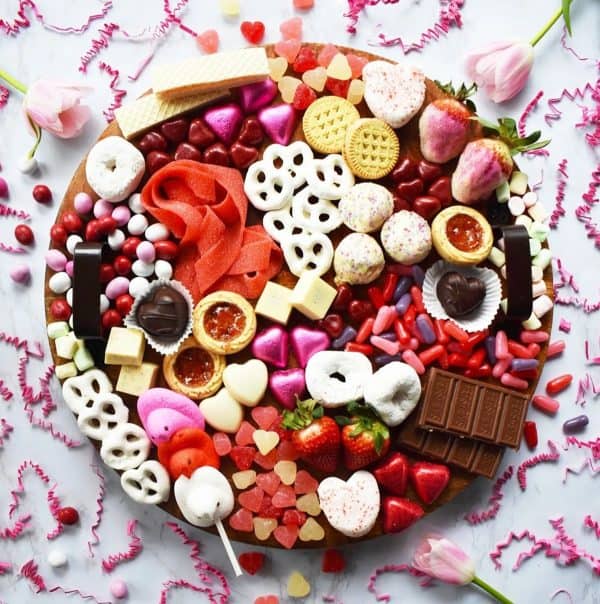 brit and co-galentines board with donuts, candy, chocolate and cookes.