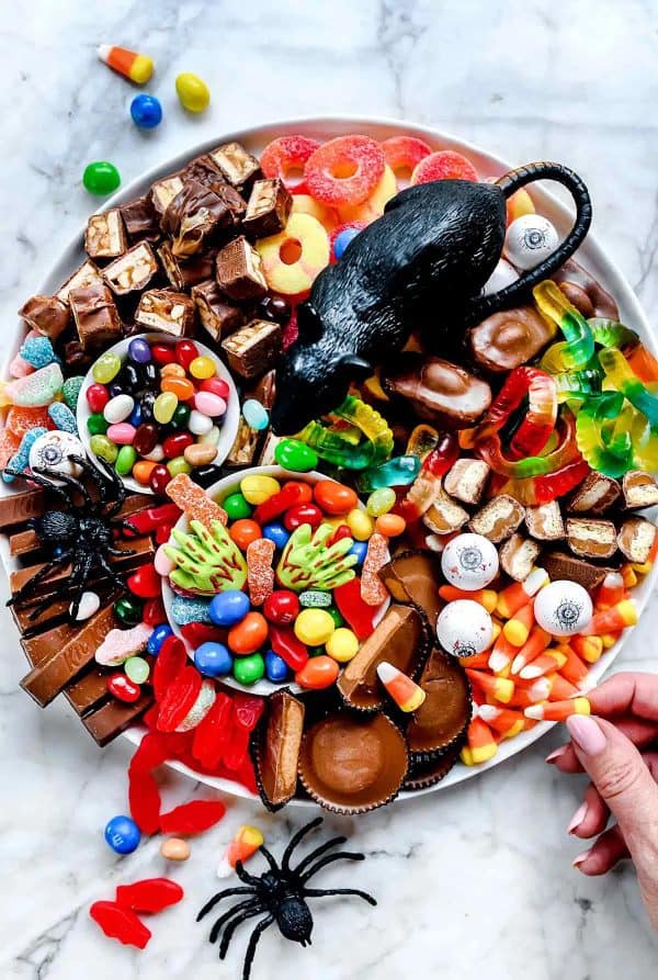 foodie crush- candy charcuterie board ideas-spooky Halloween candy board with fake rat and spiders
