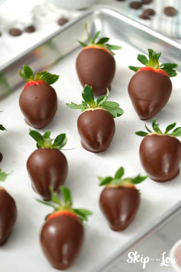 Sheet pan with 9 chocolate covered strawberries arranged in rows of 3 by Skip to my Lou.